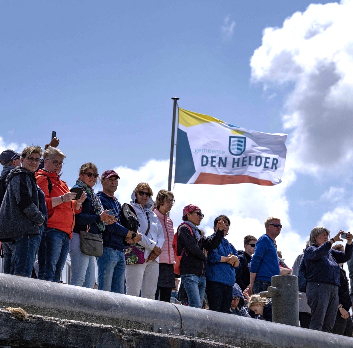 Group of people with a flag of the municipality of Den Helder